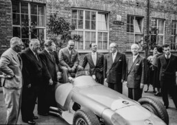 Alfred Neubauer, Mercedes-Benz Rennleiter von 1926 bis 1955 (2. von links). Abschlussfeier der Rennsaison 1955 im Mercedes-Benz Werk Untert&uuml;rkheim am 24. Oktober 1955. Von links nach rechts am Mercedes-Benz Formel-1-Rennwagen W 196 R: Piero Taruffi, Rennleiter Alfred Neubauer, Werner Engel, Karl Kling (halb verdeckt), Juan Manuel Fangio, Stirling Moss, Dr. Hermann Veit (Wirtschaftsminister von Baden-W&uuml;rttemberg), Fritz Nallinger und Andr&eacute; Simon. (Fotosignatur der Archive von Mercedes-Benz Classic: 55299-18)